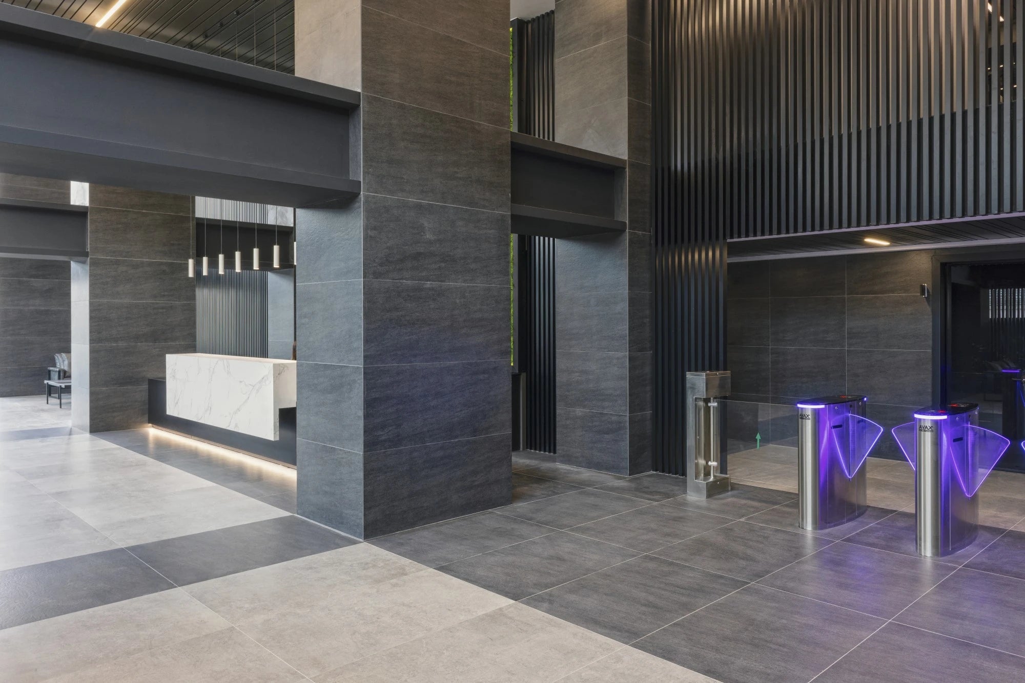 Dekton Bromo commercial lobby reception desk with dark gray textured finish and modern geometric design — premium dekton countertops installed by Signature S...