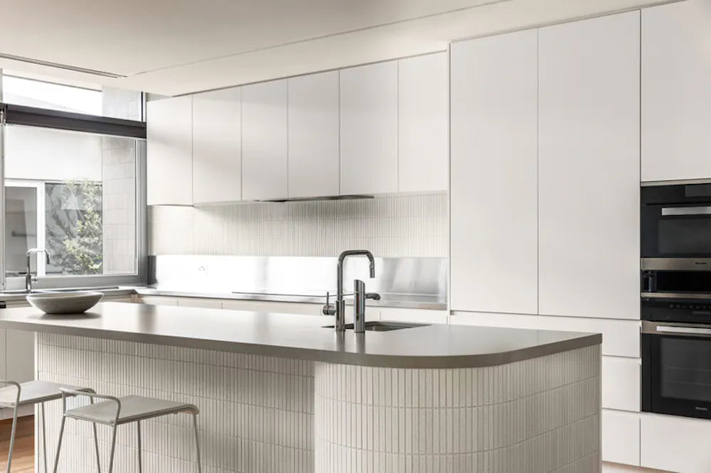 Silestone Camden quartz kitchen island with waterfall edge and matching backsplash in modern white design — quartz countertops near me by Signature Stone Las...