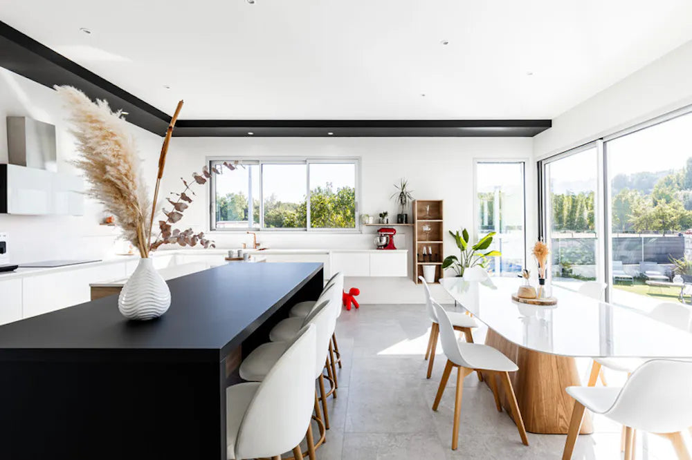 Silestone Ethereal Glow quartz kitchen island with sleek black surface and white dining table — premium quartz countertops near me by Signature Stone Las Vegas
