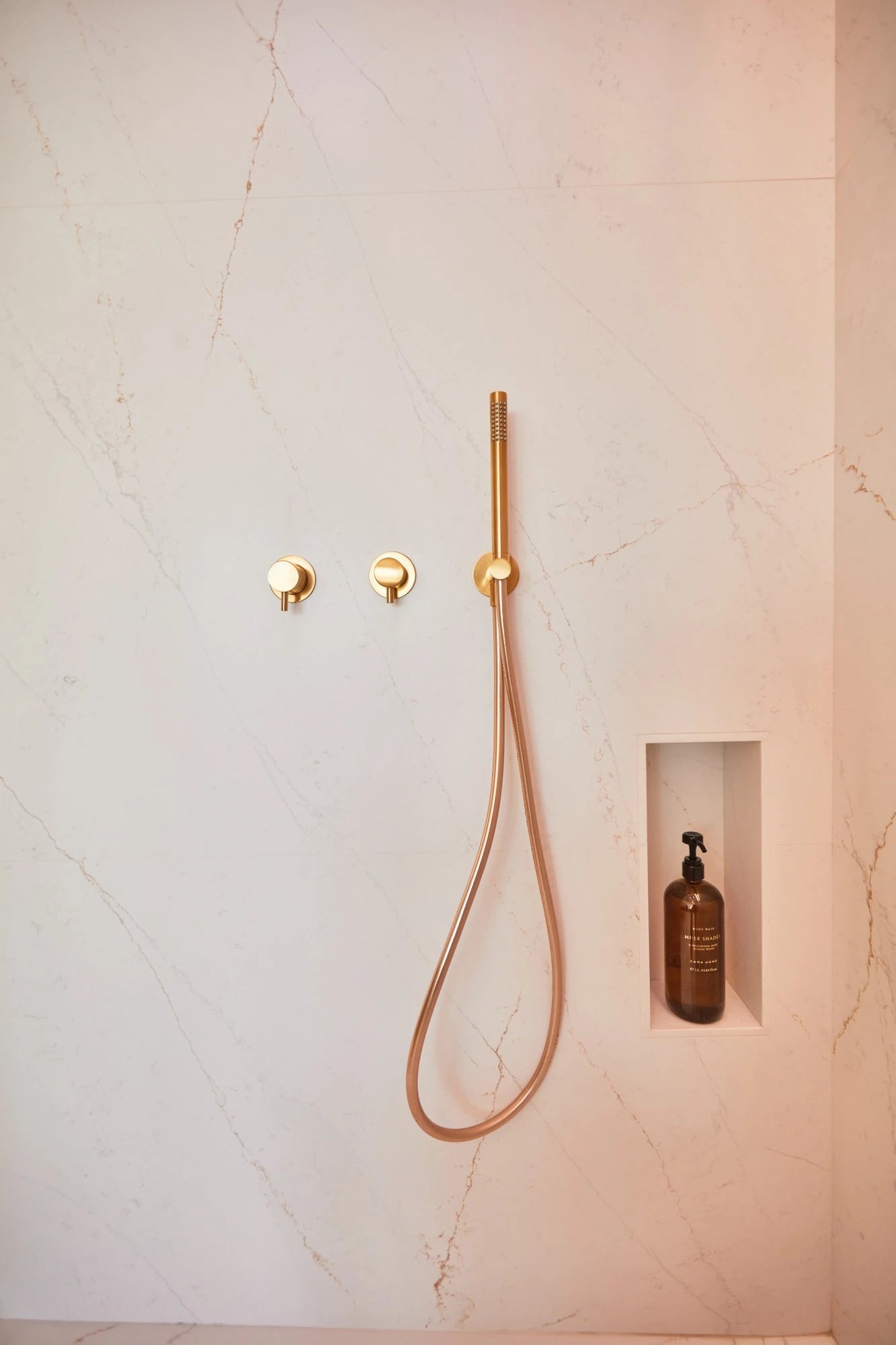 Silestone Ethereal Glow shower wall with soft pink and white veining and built-in niche — engineered quartz countertops fabricated and installed by Signature...
