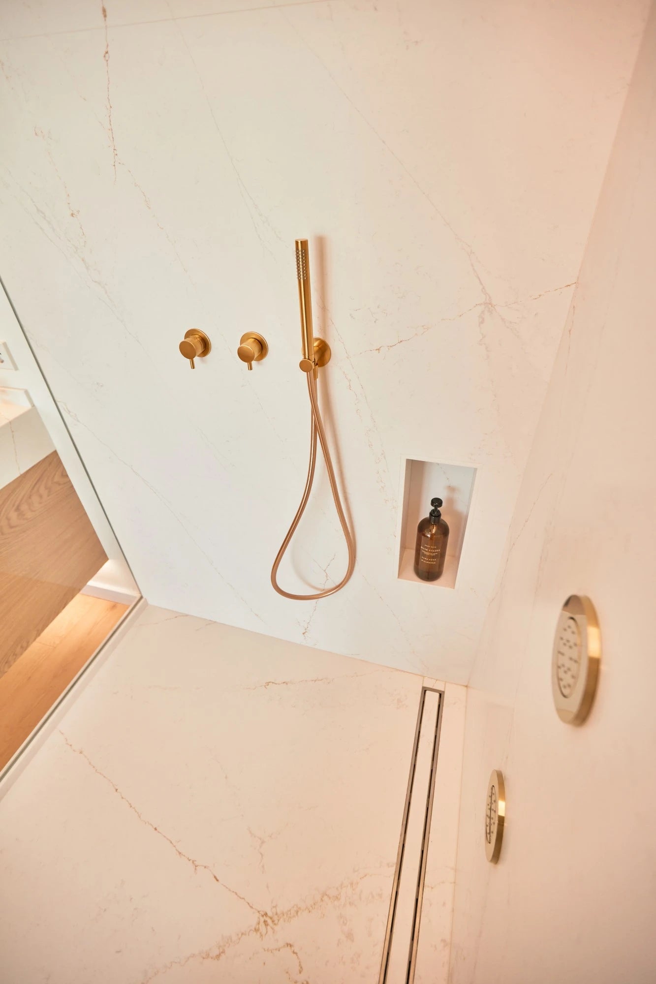 Silestone quartz shower walls with Ethereal Glow white marble veining and gold fixtures — quartz countertops near me by Signature Stone Las Vegas