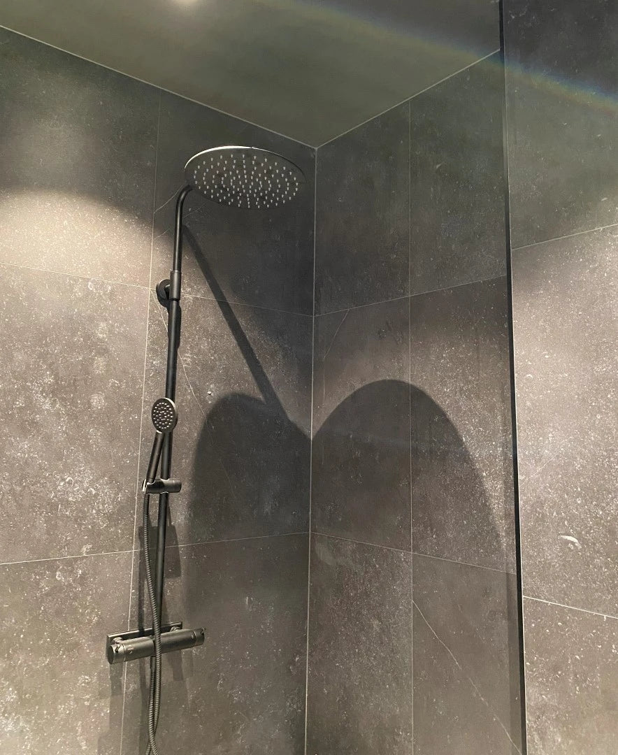 Dekton Fossil shower walls with dark gray marble-look finish and white veining — premium dekton countertops installed by Signature Stone Las Vegas