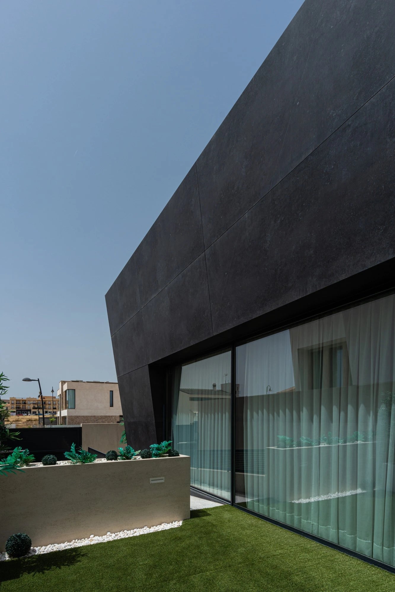 Dekton Fossil exterior cladding with dark charcoal finish on modern home facade — premium dekton surfaces fabricated and installed by Signature Stone LV