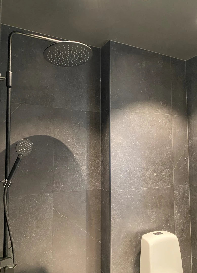 Dekton Fossil shower wall installation with dark speckled finish and sleek modern design — premium dekton surfaces fabricated and installed by Signature Ston...