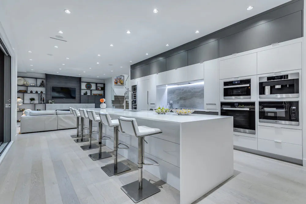 Silestone Iconic White quartz kitchen island with waterfall edge and matching perimeter counters in modern white kitchen — premium quartz countertops near me...
