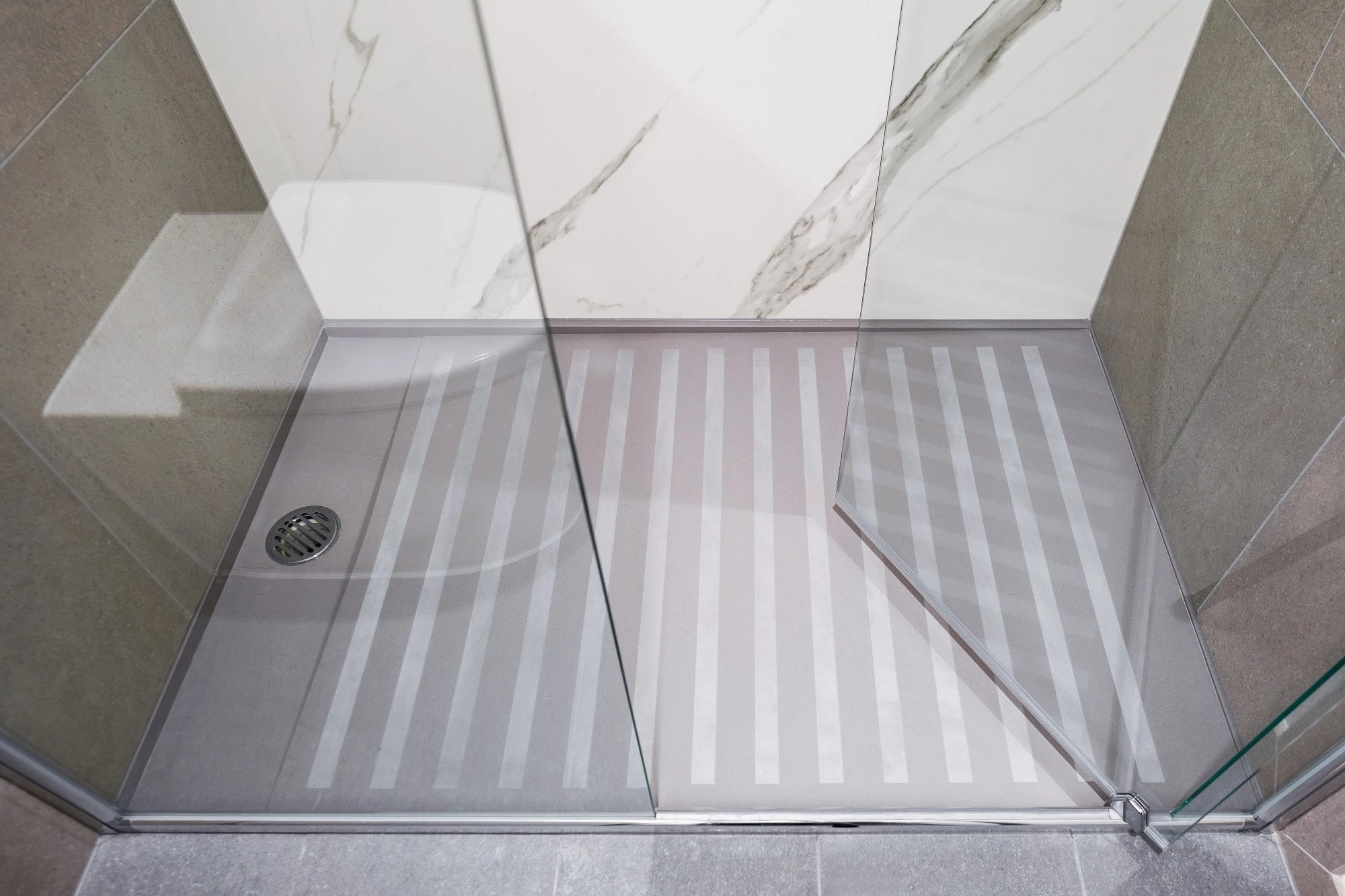 Silestone Kensho shower floor with white veined pattern and anti-slip strips — engineered quartz countertops fabricated and installed by Signature Stone LV