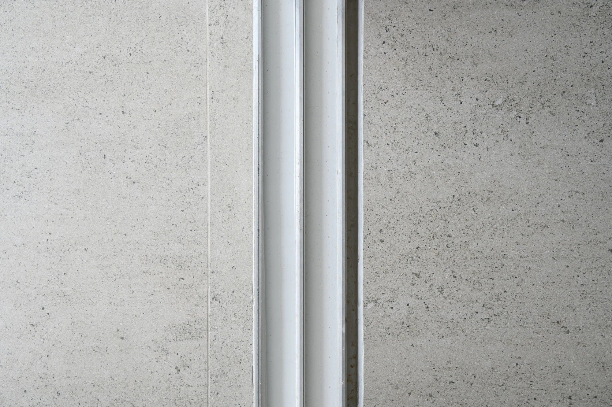 Dekton Keon wall cladding with light gray speckled finish and metal trim detail — premium dekton surfaces fabricated and installed by Signature Stone LV