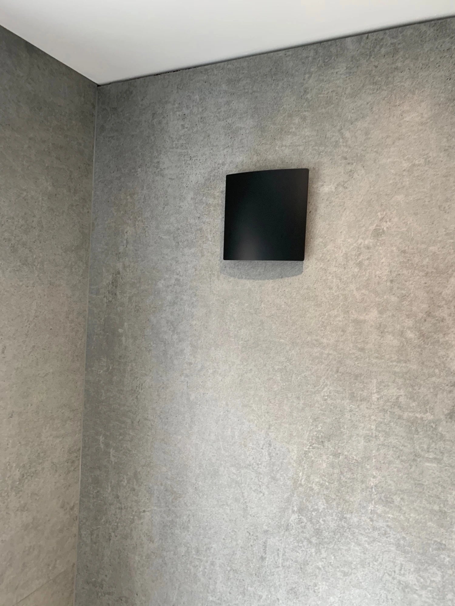 Dekton Kreta shower wall with matte gray concrete-look finish — premium dekton surfaces fabricated and installed by Signature Stone LV