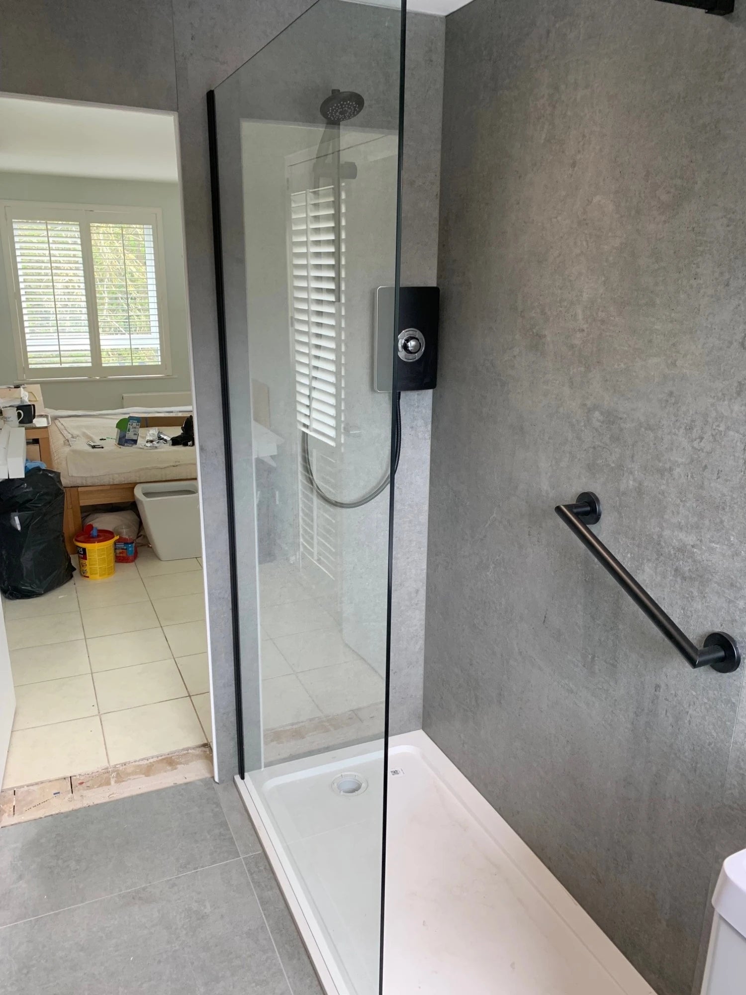 Dekton Kreta shower walls with matte gray concrete-look finish — premium dekton surfaces fabricated and installed by Signature Stone LV