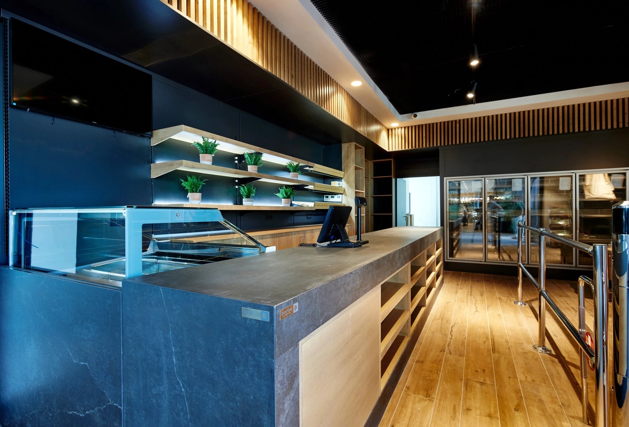 Dekton Laos kitchen island with dark gray finish and waterfall edge — premium dekton surfaces fabricated and installed by Signature Stone LV