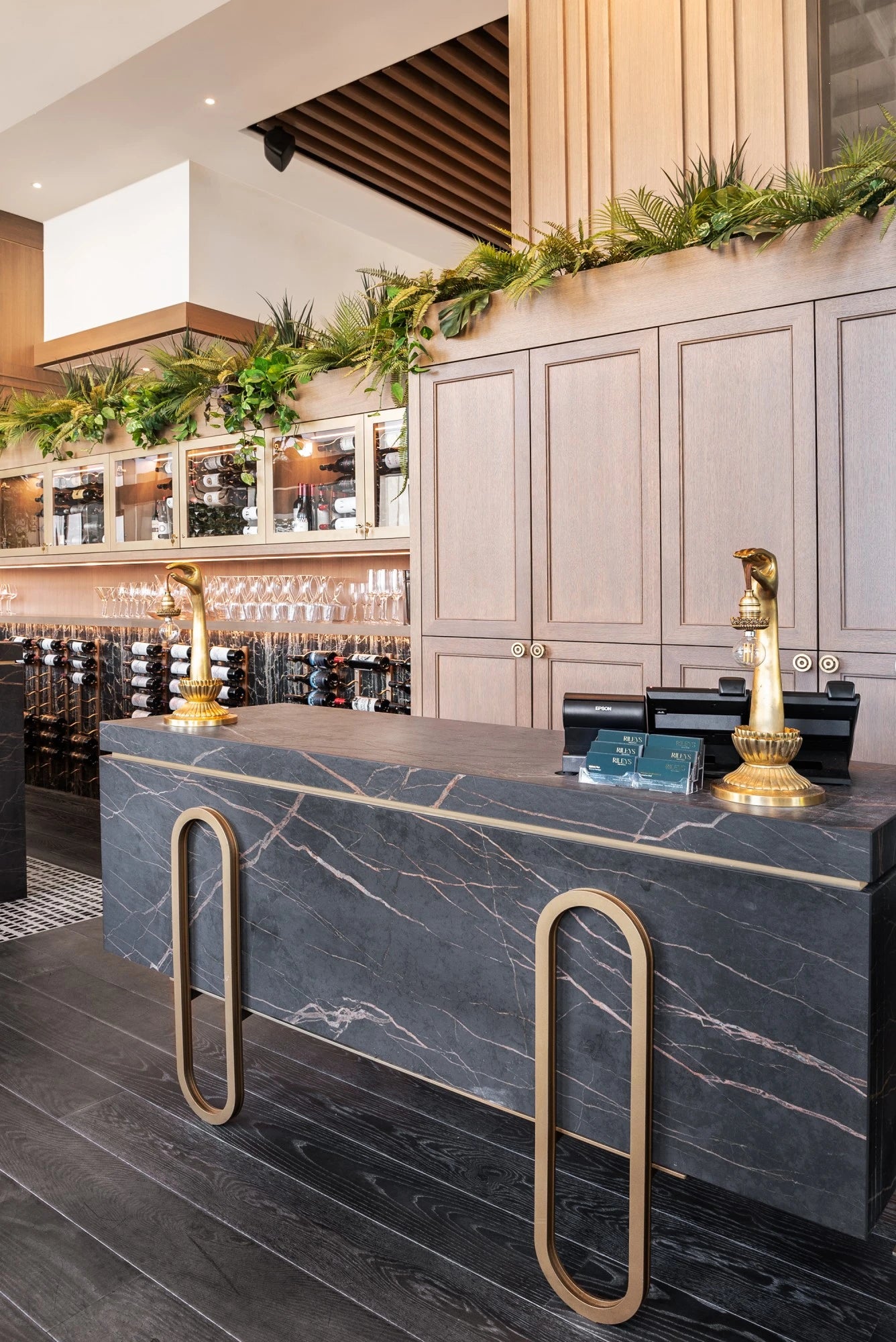 Dekton Laurent kitchen island with dark marble veining and gold bar stools — dekton countertops installed by Signature Stone Las Vegas