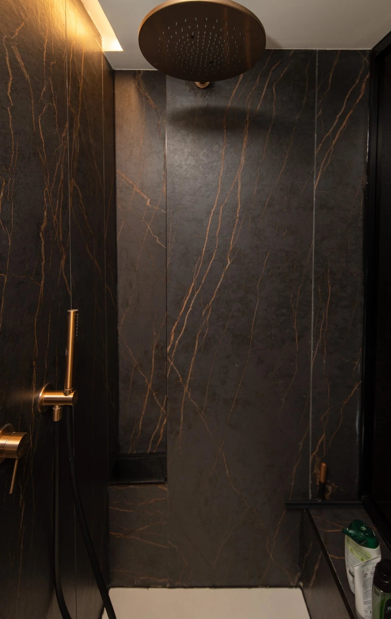 Dekton Laurent shower surround with dark marble-look veining and gold fixtures — dekton kitchen countertops by Signature Stone Las Vegas