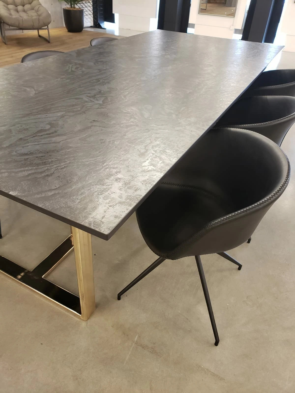 Dekton Liquid Embers dining table surface with gray wood-grain pattern and gold metal base — dekton kitchen countertops by Signature Stone Las Vegas