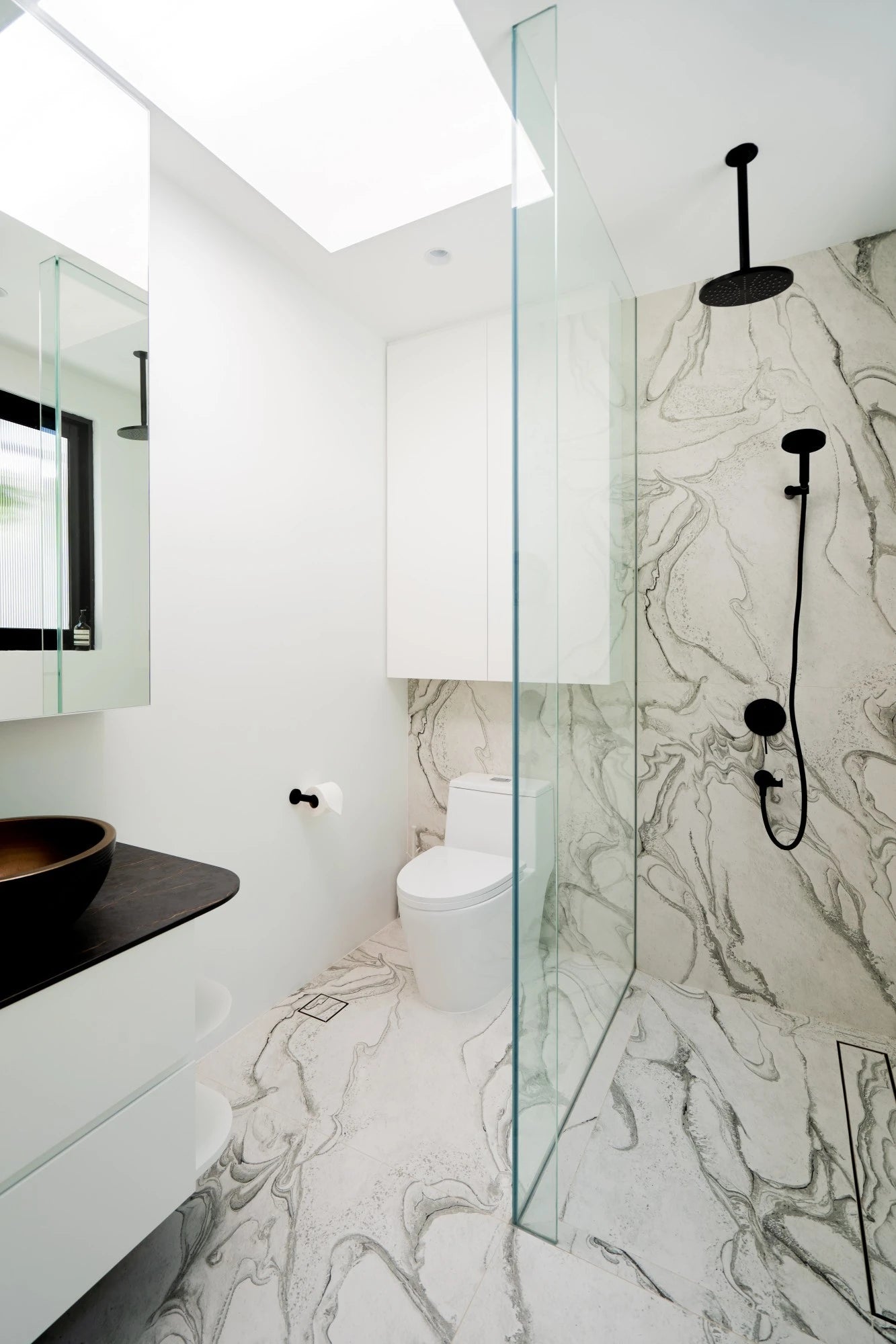 Dekton Liquid Sky bathroom flooring and shower walls with flowing white marble veining — premium dekton surfaces fabricated and installed by Signature Stone LV