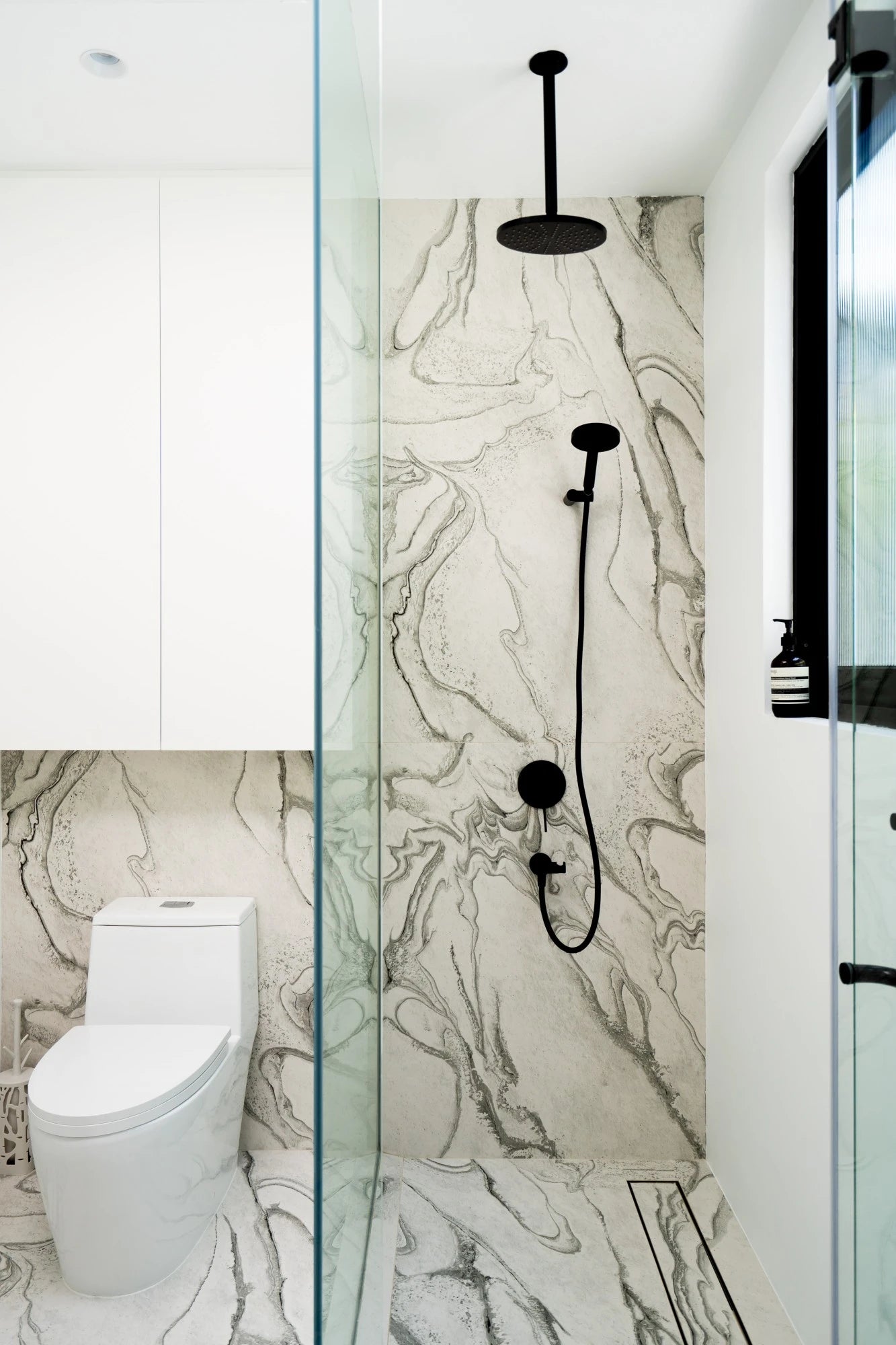 Dekton Liquid Sky bathroom walls with flowing marble-like veining and matte finish — dekton countertops installed by Signature Stone Las Vegas