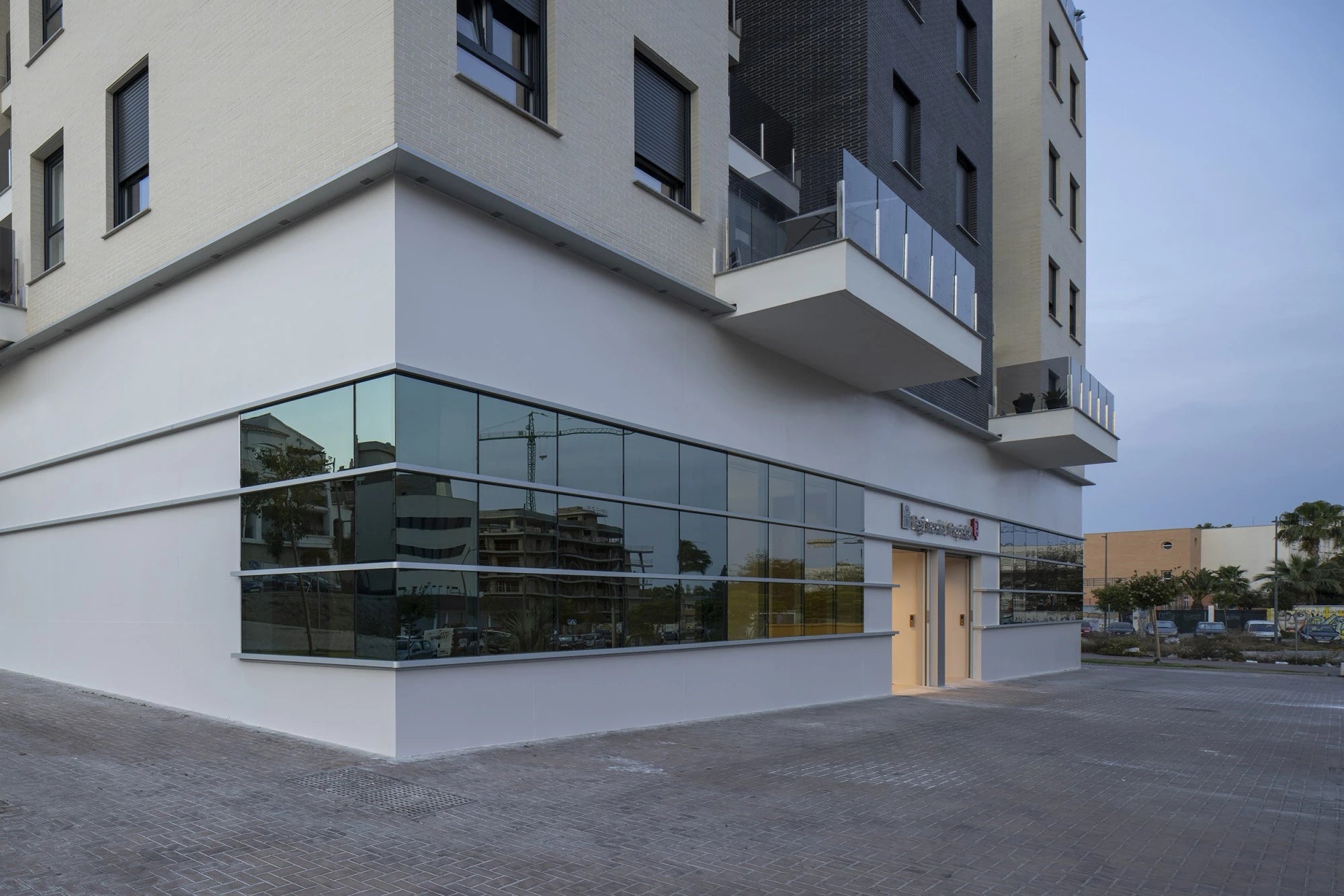 Dekton Moone commercial building exterior with sleek glass windows and modern white facade — premium dekton surfaces fabricated and installed by Signature St...