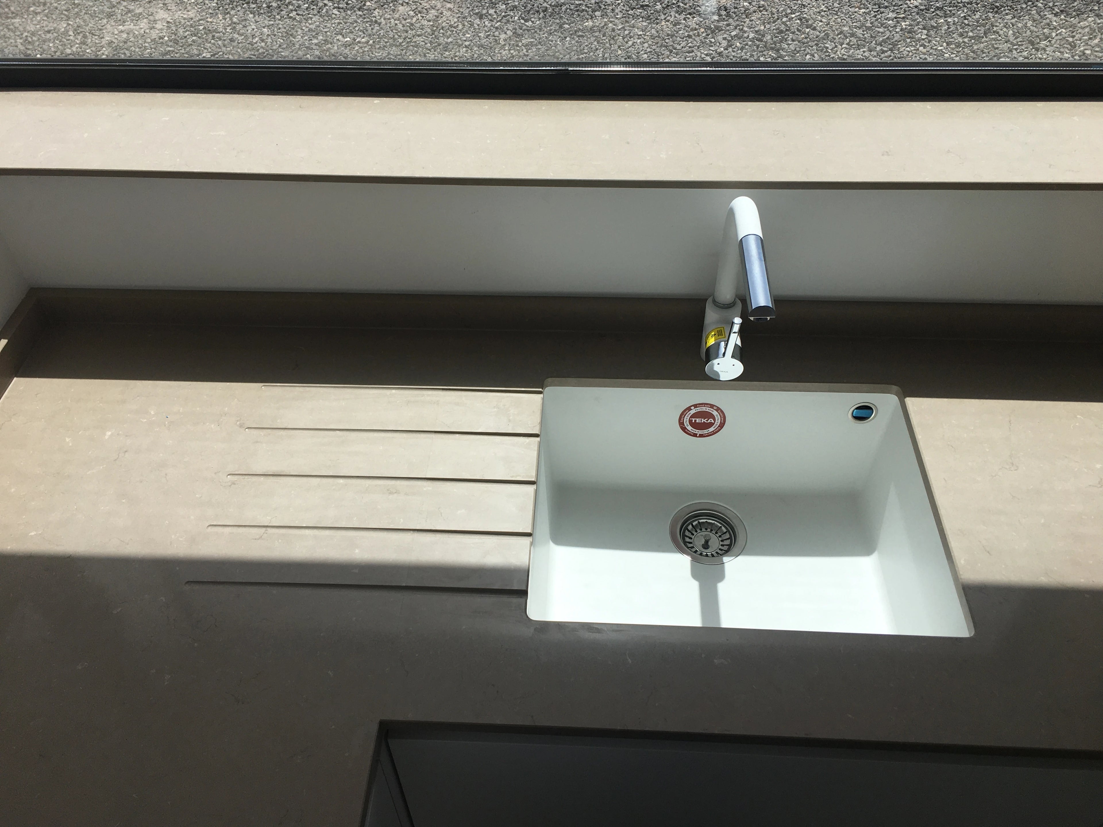 Silestone Noka kitchen countertop with integrated white sink and grooved draining board in dark gray finish — quartz countertops installed by Signature Stone...
