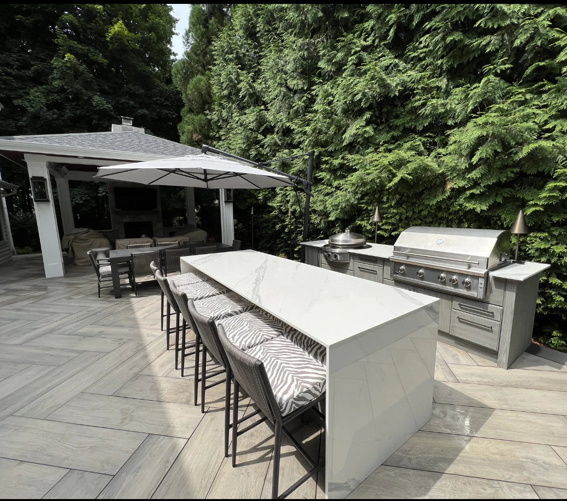 Dekton Olimpo outdoor kitchen island with waterfall edge in light gray finish — premium dekton surfaces fabricated and installed by Signature Stone LV