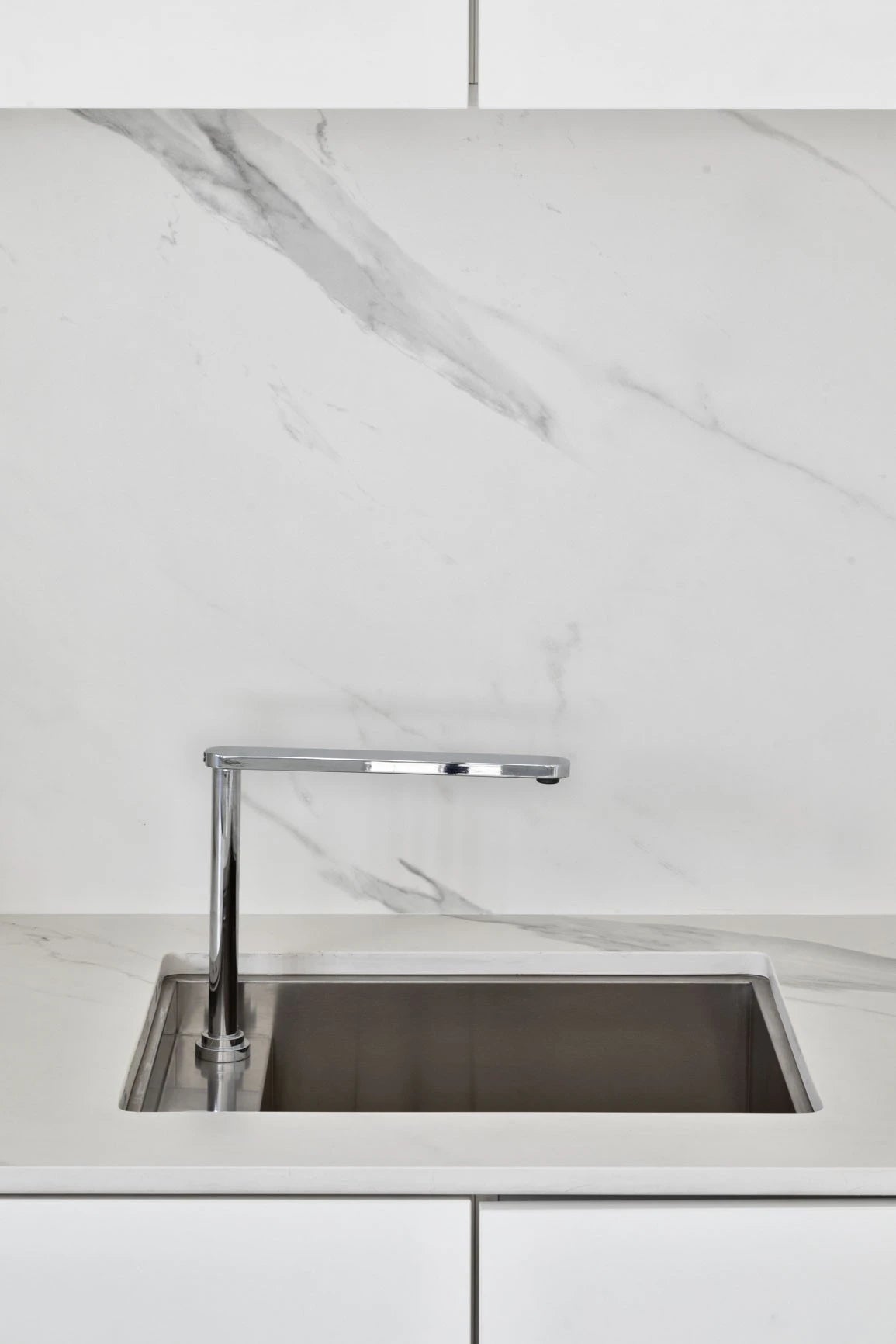 Dekton Opera kitchen countertop with undermount sink and chrome faucet featuring white marble-look veining — premium dekton surfaces fabricated and installed...