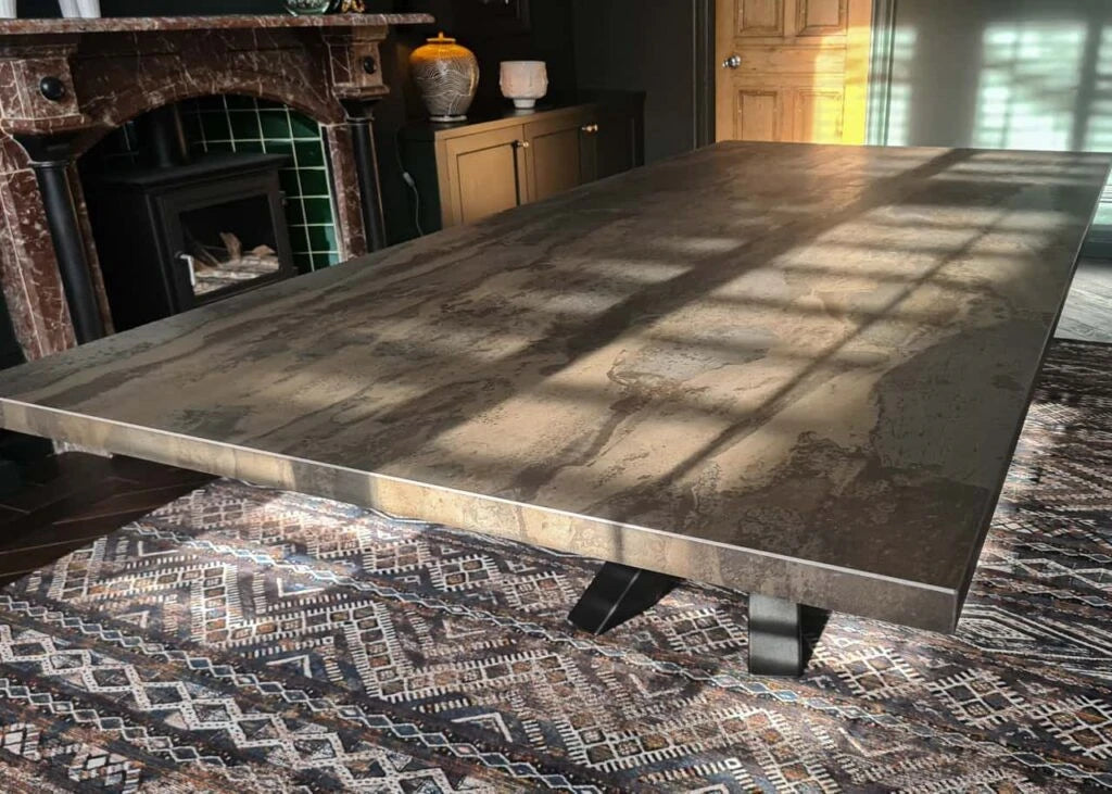 Dekton Radium dining table with concrete-look gray finish and black metal legs — premium dekton surfaces fabricated and installed by Signature Stone LV