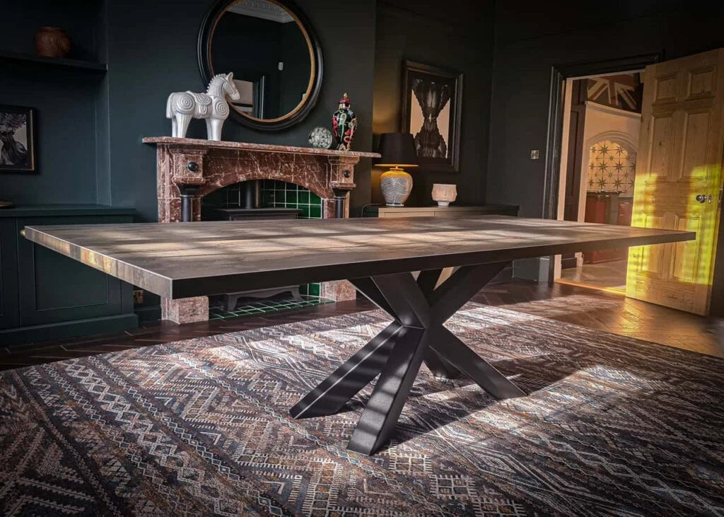 Dekton Radium dining table with rich wood grain pattern and dark metal X-base — premium dekton kitchen countertops by Signature Stone Las Vegas