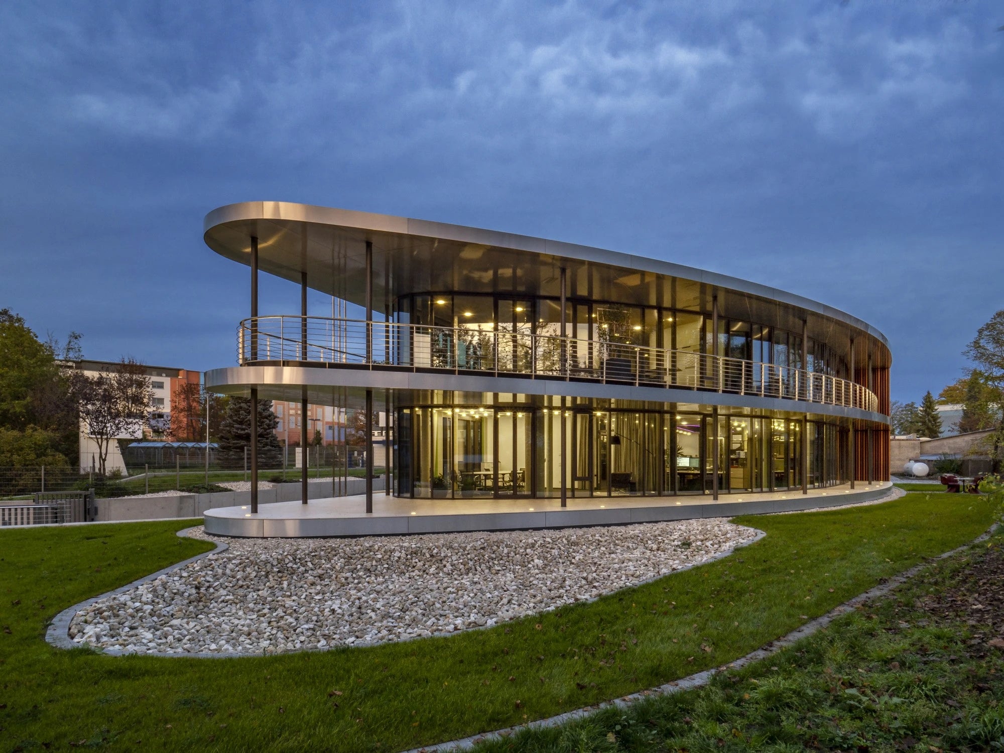 Dekton Sasea modern building facade with curved glass walls and warm lighting — premium dekton surfaces fabricated and installed by Signature Stone LV