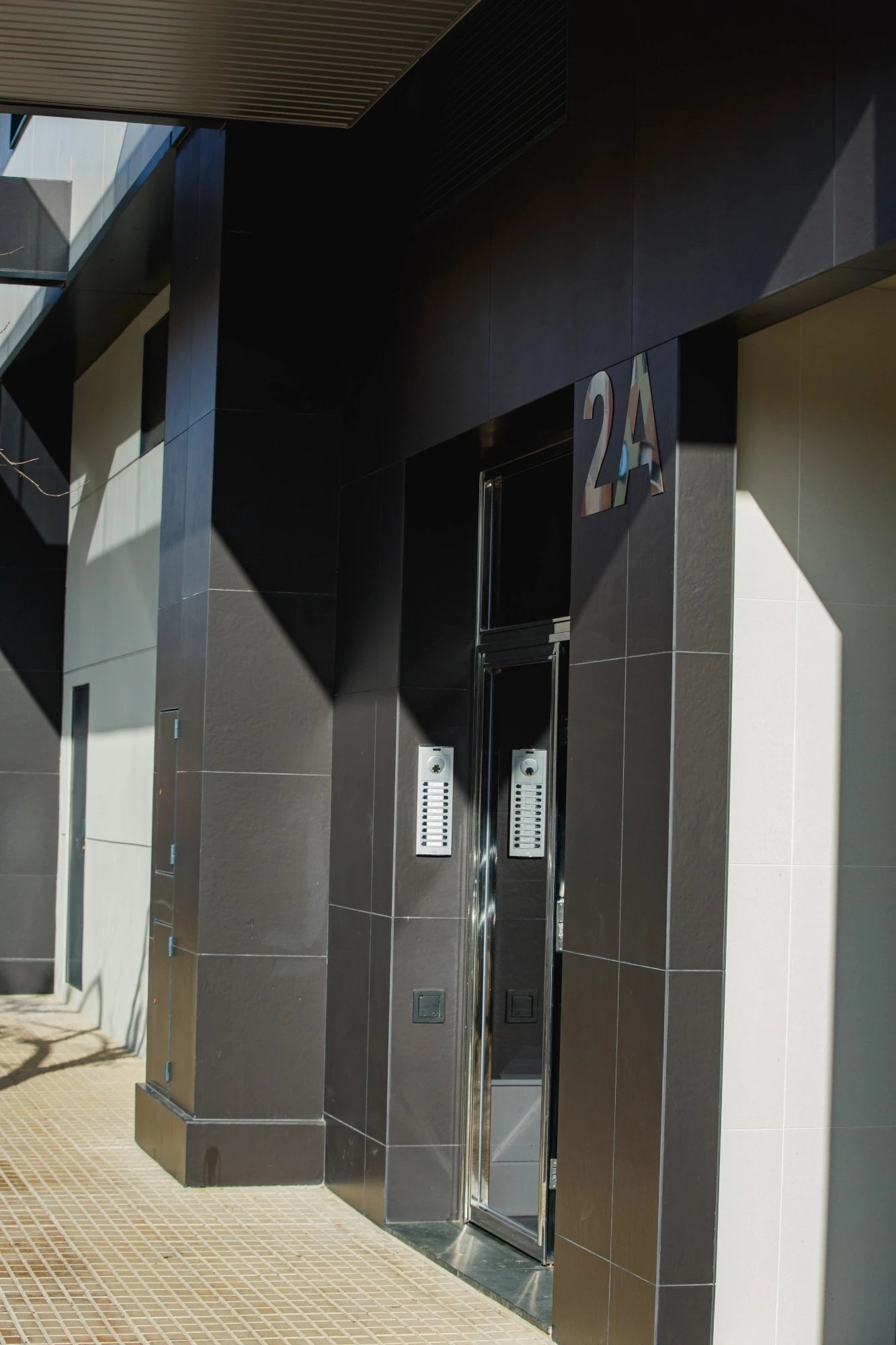 Dekton Sirius exterior cladding with dark gray finish on modern building entrance — showcasing dekton kitchen countertops by Signature Stone Las Vegas