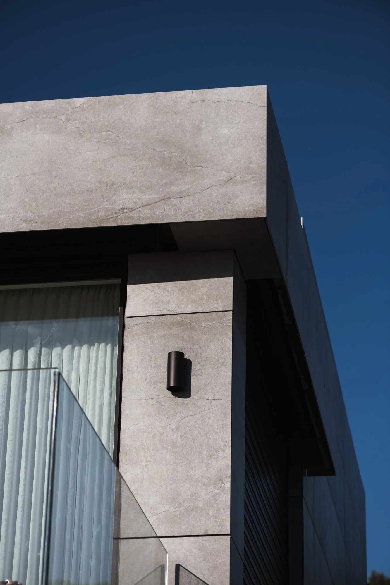 Dekton Soke exterior wall cladding with light gray marble-like veining and matte finish — premium dekton surfaces fabricated and installed by Signature Stone LV