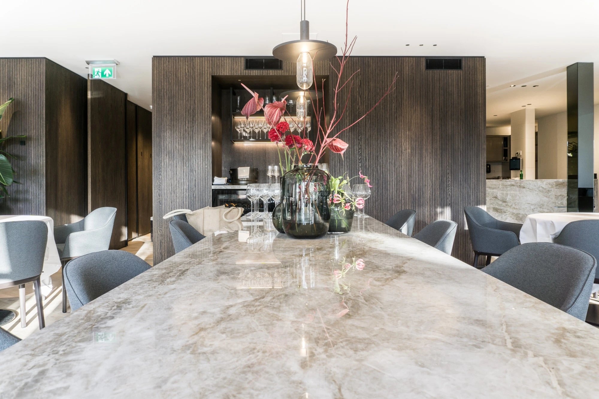 Dekton Taga dining table with polished marble-like finish and gray veining — premium dekton surfaces fabricated and installed by Signature Stone LV