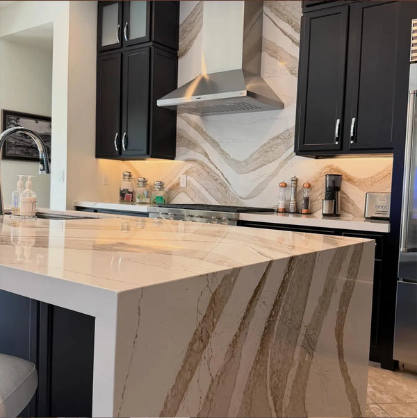 Modern kitchen with quartzite waterfall island, stone backsplash, and dark cabinets