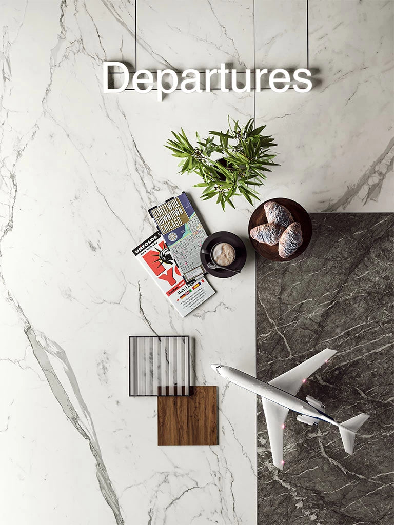 Statuario Supremo marble surface with white and gray veining displayed with travel items — premium countertop fabrication by Signature Stone Las Vegas