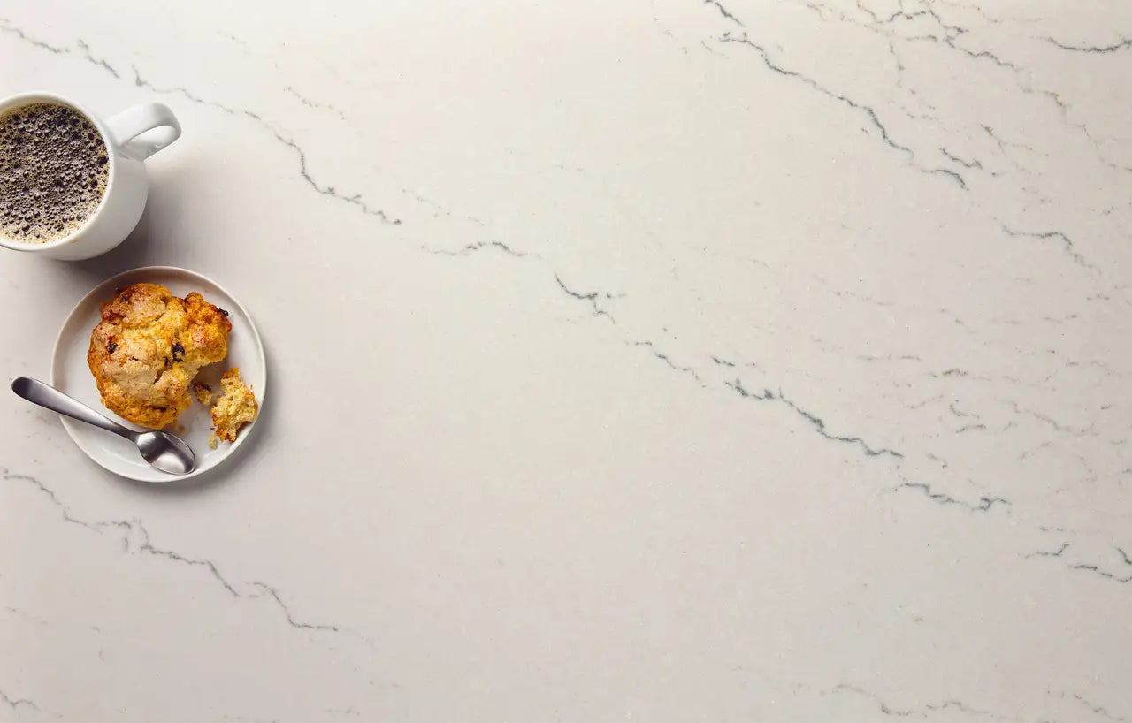 Quartz countertop surface with white marble veining and golden baked goods — premium countertop fabrication by Signature Stone Las Vegas