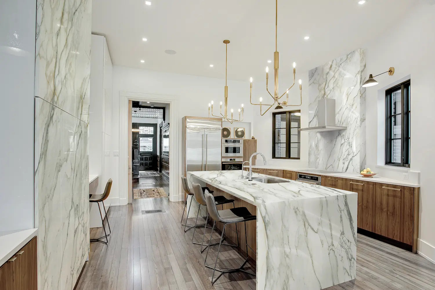 Calacatta marble kitchen island and backsplash with dramatic white veining and waterfall edge — premium stone countertops installed by Signature Stone Las Vegas