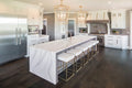 Brittanicca quartz kitchen island with dramatic white veining and waterfall edge — premium stone countertops installed by Signature Stone Las Vegas