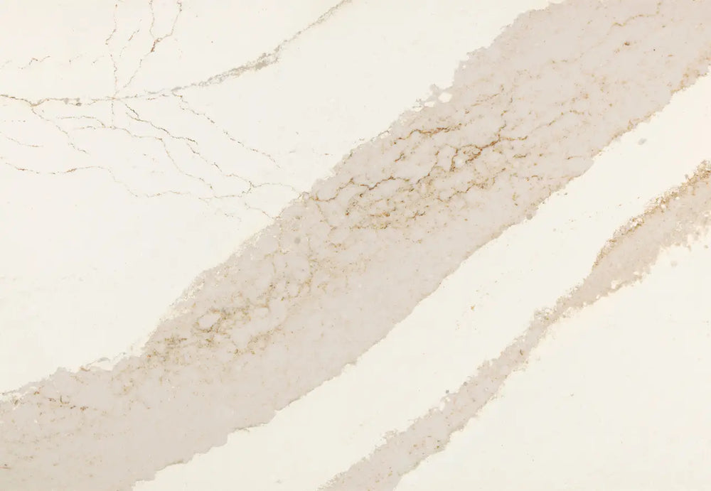 Brittanicca Gold Cool quartz slab with soft beige tones and subtle golden veining throughout the polished surface — custom countertops fabricated and install...
