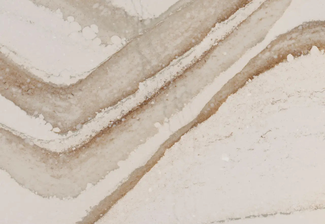 Brittanicca Gold Warm quartz surface with flowing beige and cream veining patterns — premium stone countertops installed by Signature Stone Las Vegas