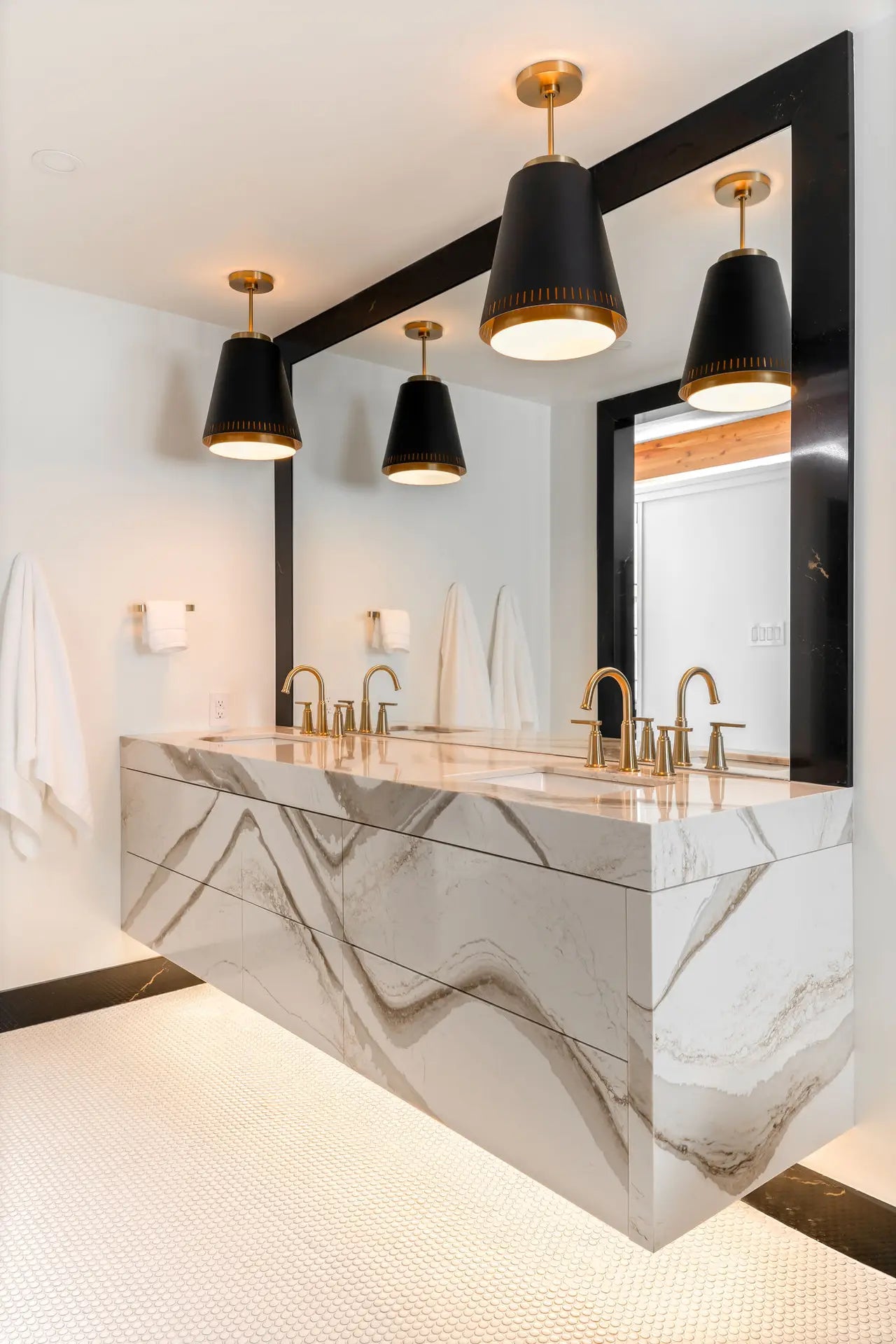 Brittanicca Gold Warm marble bathroom vanity with dramatic veining and waterfall edge — luxury stone countertops installed by Signature Stone Las Vegas
