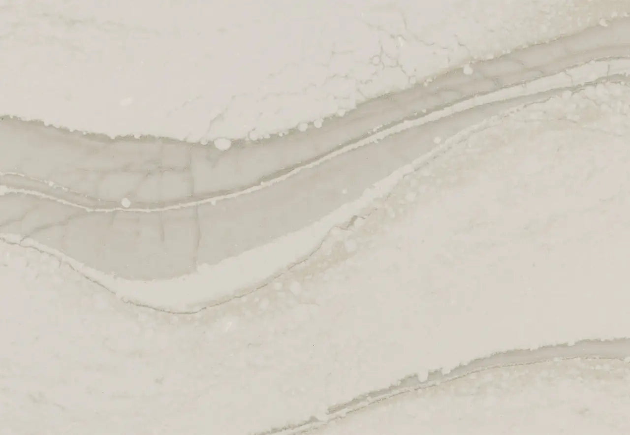 Brittanicca Warm quartz surface with flowing beige and cream veining and polished finish — custom countertops fabricated and installed by Signature Stone LV