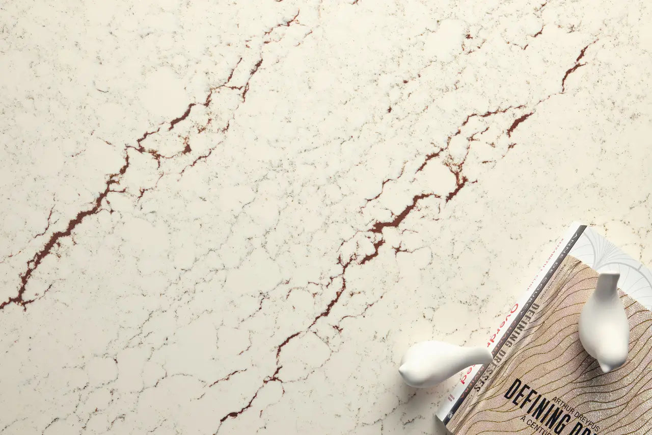 Cashel quartz surface featuring cream background with burgundy veining and polished finish — custom countertops fabricated and installed by Signature Stone LV
