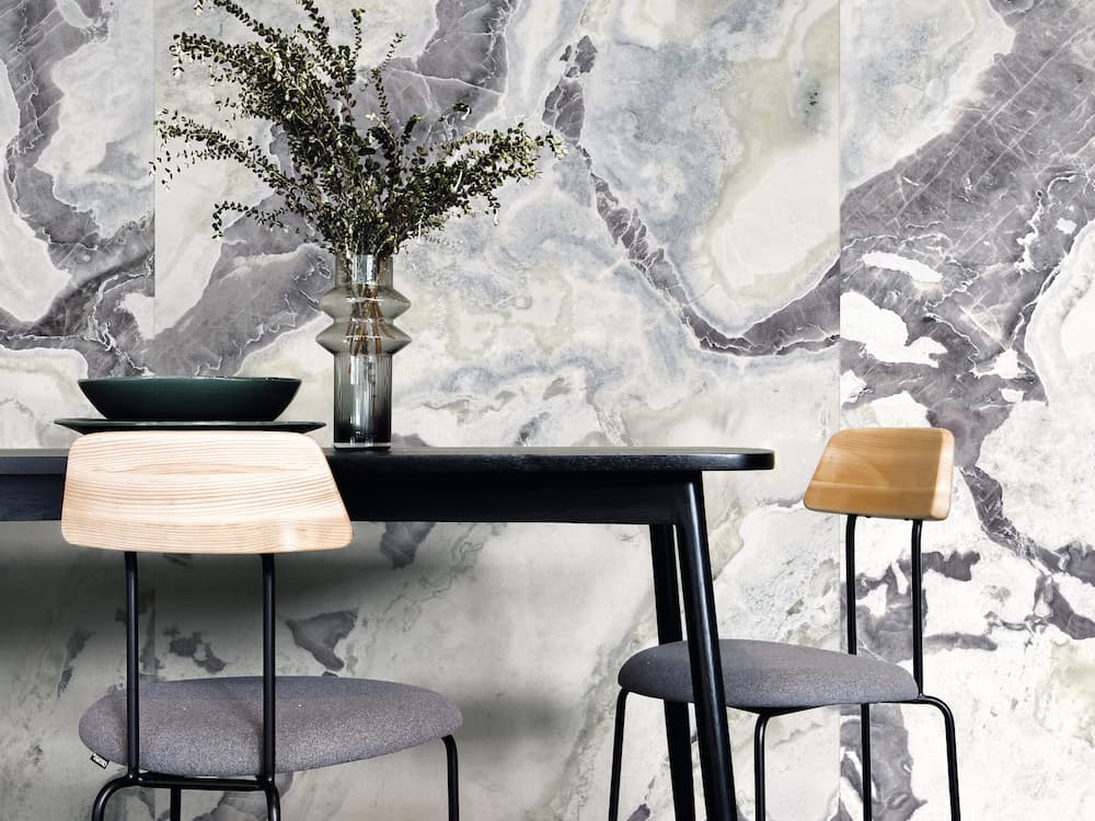 Dover White quartz dining table with dramatic gray marble wall backdrop — elegant stone countertops installed by Signature Stone Las Vegas