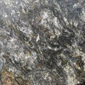 close-up of polished granite slab with dark and metallic silver veining for countertops
