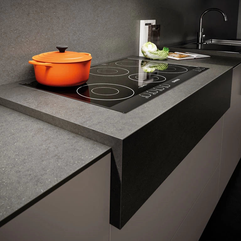 Basaltina Volcano kitchen island with dark speckled finish and induction cooktop — expert countertop fabrication by Signature Stone Las Vegas