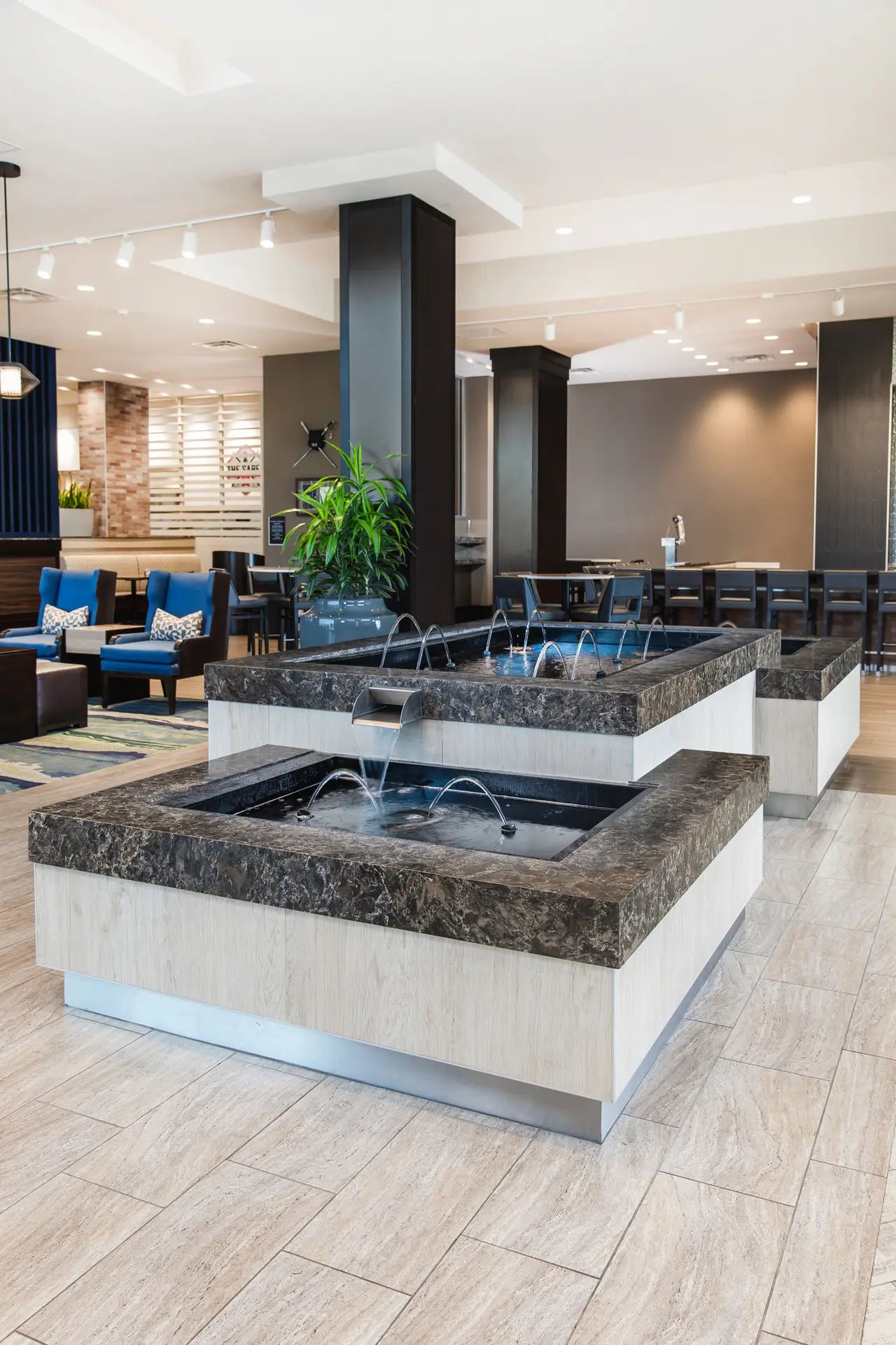 Laneshaw stone fountain feature with dark granite surfaces and white base in modern lobby — expert countertop fabrication by Signature Stone Las Vegas