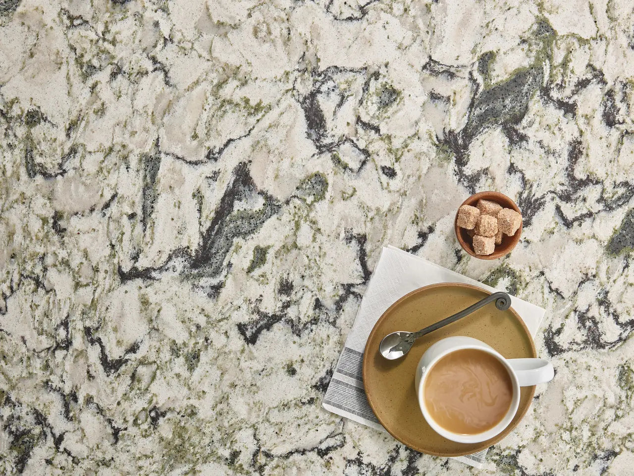 Sherwood quartz surface with cream base and gray veining displayed with coffee cup — elegant custom countertops fabricated and installed by Signature Stone LV