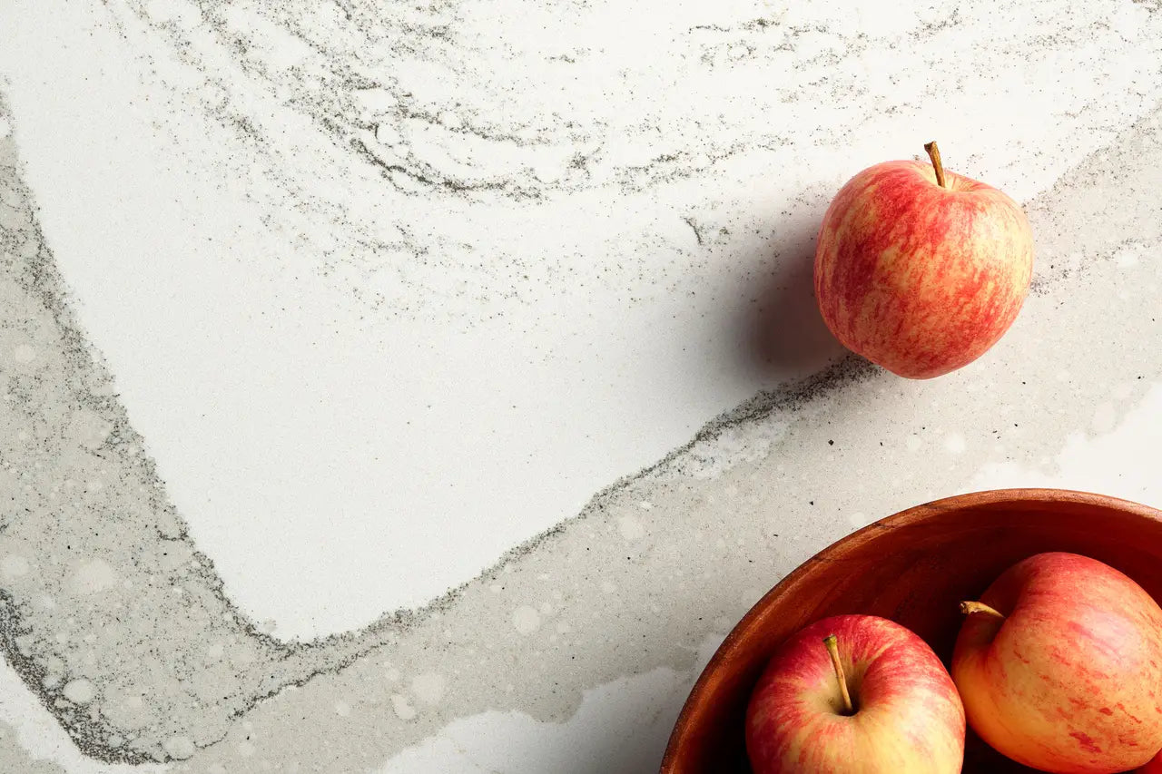 Red apples on white marble surface with gray veining and smooth polished finish — premium countertop fabrication by Signature Stone Las Vegas
