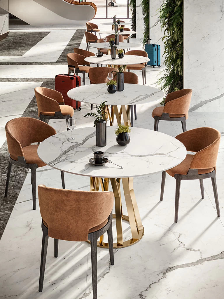 Statuario Supremo marble dining tables with white veined surfaces and gold pedestals — elegant stone countertops installed by Signature Stone Las Vegas