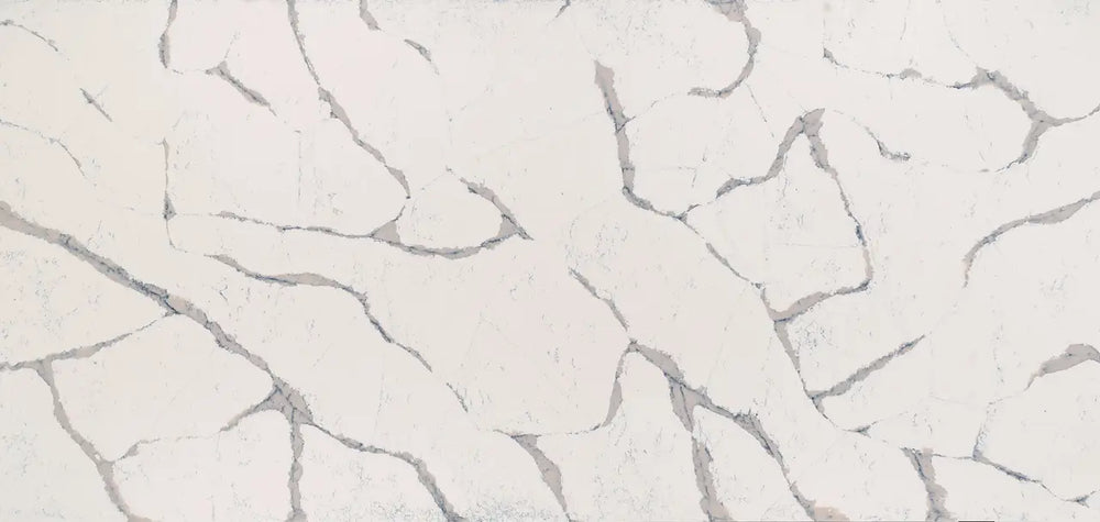Quartz surface with soft white background and gray veining in organic flowing patterns — custom countertops fabricated and installed by Signature Stone LV