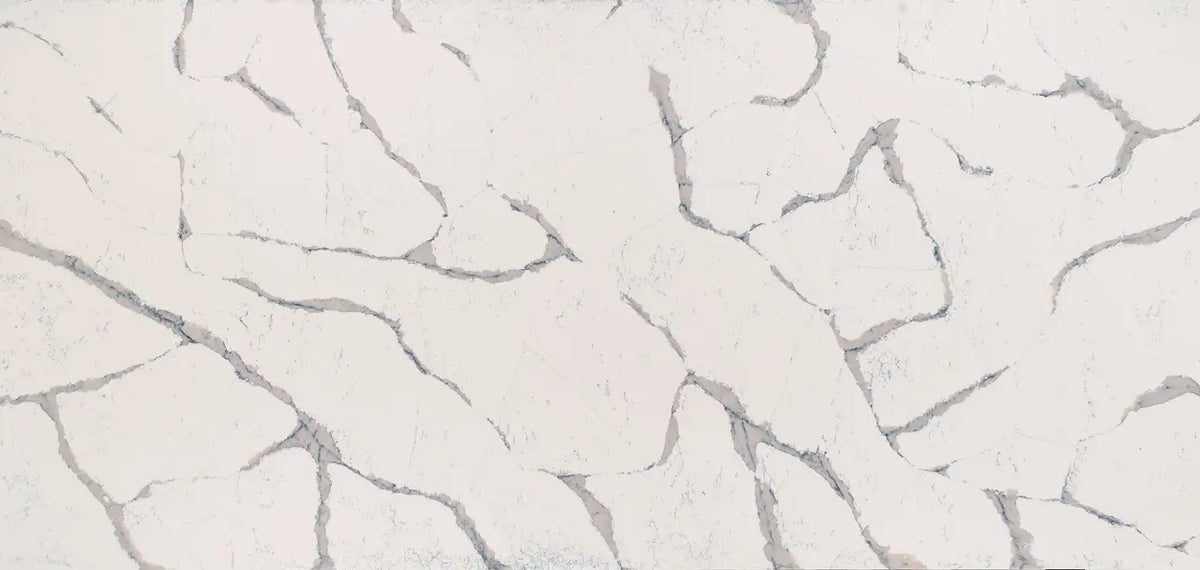 Quartz surface with soft white background and gray veining in organic flowing patterns — custom countertops fabricated and installed by Signature Stone LV