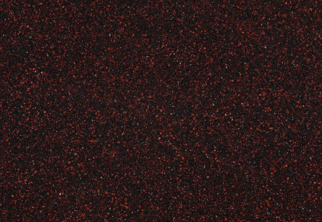 Granite Wilshire Red surface with deep burgundy background and scattered red speckles — premium stone countertops installed by Signature Stone Las Vegas