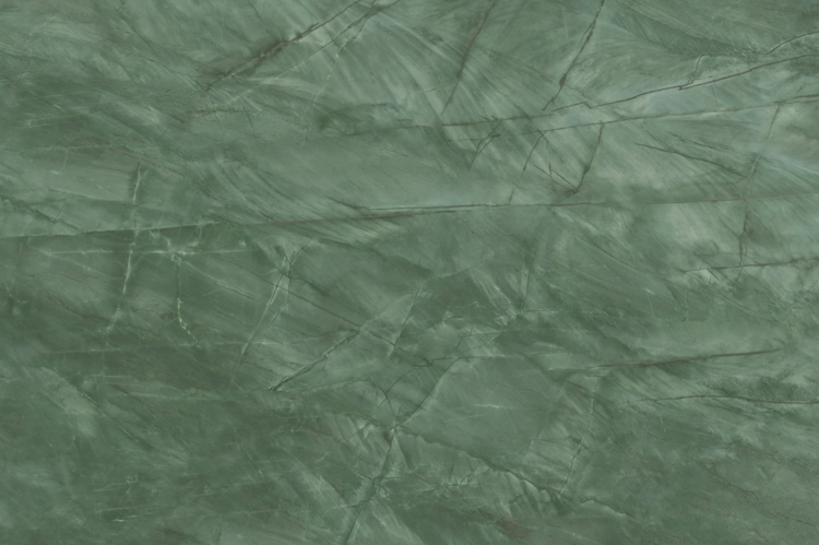 A close-up of a textured green marble surface with intricate, natural white and dark green veining and patterns throughout.